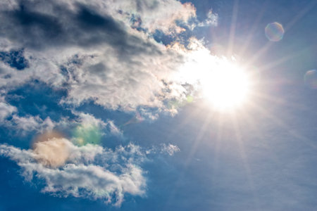 The Sun and clouds in the blue sky