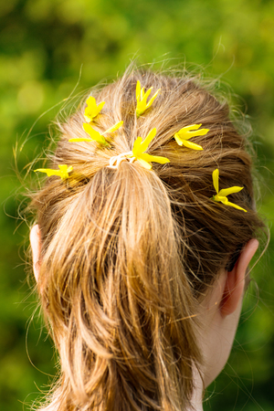 A Young woman with plait and yellow flowers in hairの写真素材