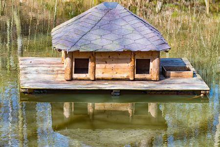 A Small wooden house floats in the middle of the waterの写真素材