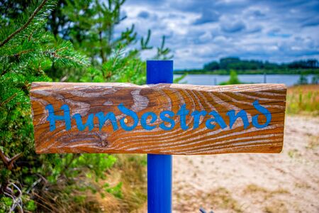 Wooden sign shows the way to the dog beachの写真素材