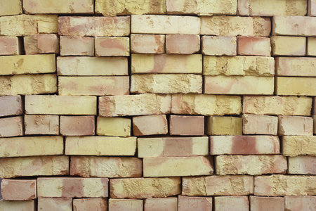 Wall of stacked bricks. New bricks made of clay, manufacturing quality is poor.の写真素材
