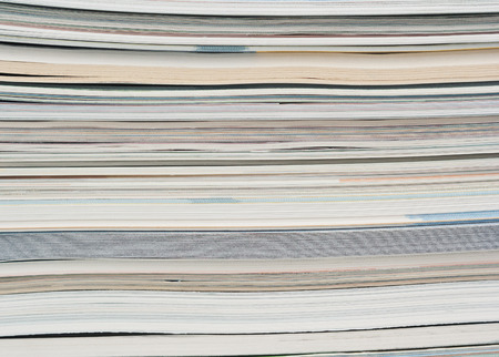 Side view of a stack of paper, books and magazines.の写真素材