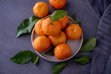Fresh tangerines with leaves on a dark background. Selective focus.