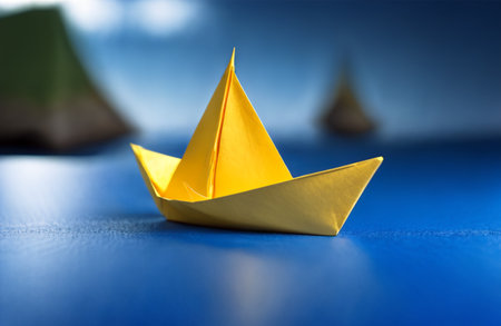 Paper boat on blue background. Concept of leadership and success in businessの素材
