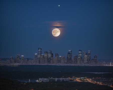cityscape at night with full moon and dramatic sky, long exposureの素材