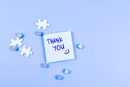 THANK YOU note with smiley face, puzzle pieces, and wooden cubes conveys gratitude through playful, creative visual arrangement.の写真素材
