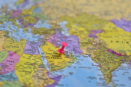 Middle East political map with pink pushpin marking Saudi Arabia, surrounded by labeled countries including Egypt, Iran, Iraq, and Turkey.の写真素材