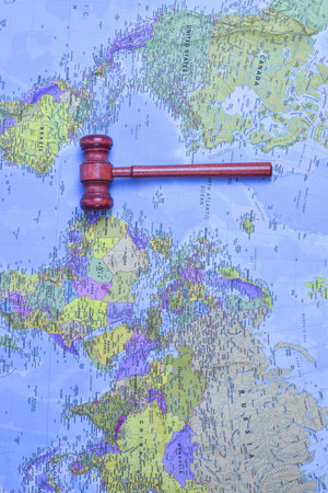 Red gavel on world map symbolize global justice, legal urgency, and international decision-making across geographic boundaries.の写真素材