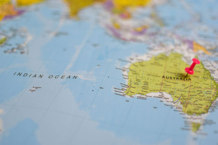 World map close-up with red pushpin marking eastern Australia, showing surrounding regions including...