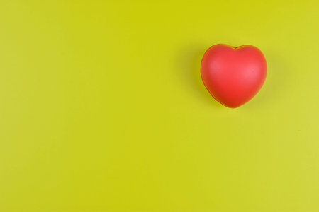 Red heart on yellow surface represents emotional value.