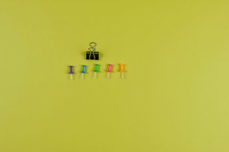 Colorful push pins on yellow-green surface highlight organization, planning, and visual contrast in office or educational settings.の写真素材