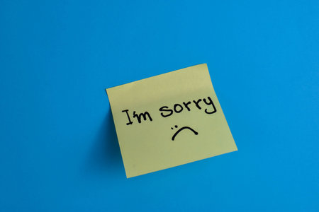 Yellow sticky note with I Am Sorry message on blue background, conveying warmth through simple text and strong color contrast.の写真素材