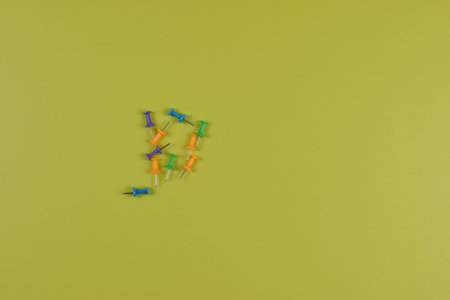 Colorful push pins on yellow-green surface highlight organization, planning, and visual contrast in office or educational settings.の写真素材