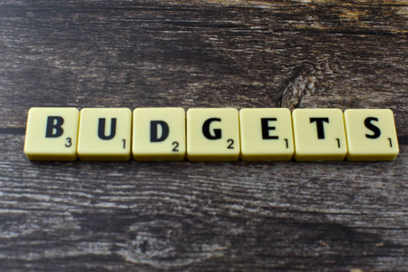 Scrabble tiles spell Budgets on wood, representing financial planning, resource allocation, and strategic management in economic or organizational contexts.の写真素材