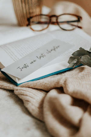 hygge flatlay photo of a book sweater and a bookmarkの写真素材