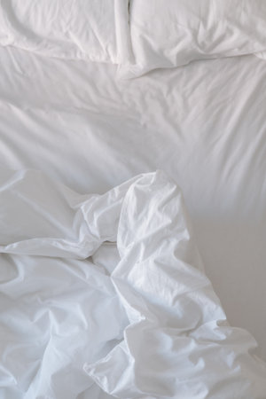 White bedding sheets and blanket in bedroom, soft focus background.の写真素材