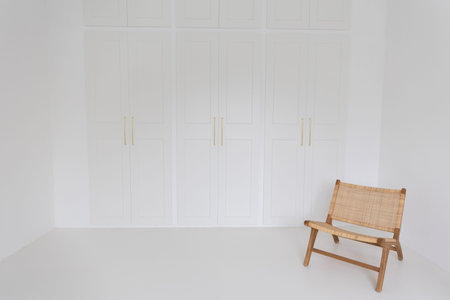 Wooden chair in white room. White wall background with wooden cabinet.の写真素材