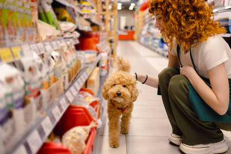 Young woman with poodle in pet shop