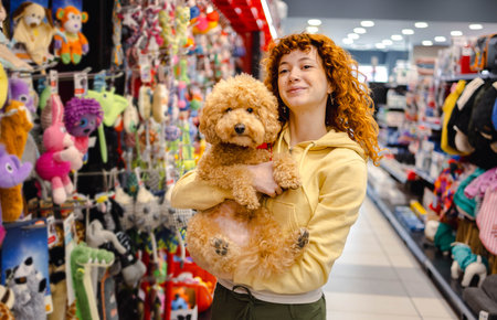 Young woman with poodle in pet shop
