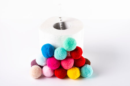Roll of toilet paper that has a syringe inside and is surrounded by sponge balls. The photo is a...