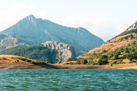 Landscape of the mountains of the Porma reservoir in Castilla y Leon.The photograph is taken from the water's edge, which is reached by a detour along a curvy road that is heavily visited by motoristsの写真素材