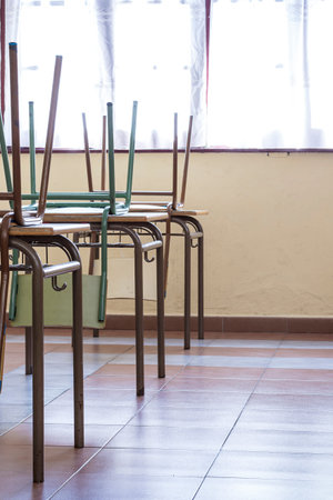 Infant school chairs raised on top of the desks.