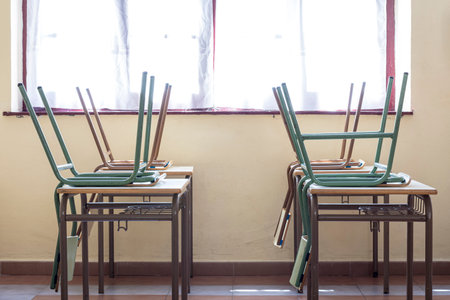 Photograph of children's chairs on the desks of a nursery school.The photo is taken in horizontal format.の写真素材