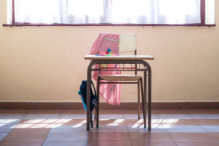 Photograph of a desk and chair in a primary classroom where you can see the typical material of a child student.の写真素材