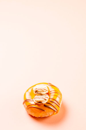Photograph of a cream donuts decorated with two cookies and drawn with chocolate.The photo is taken vertically on a cream-colored background.の写真素材