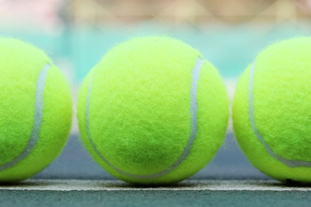 Photo of brand new tennis balls arranged in a rowの写真素材