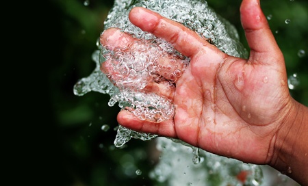 Fresh clean and pure bubbling water splashing on handの写真素材