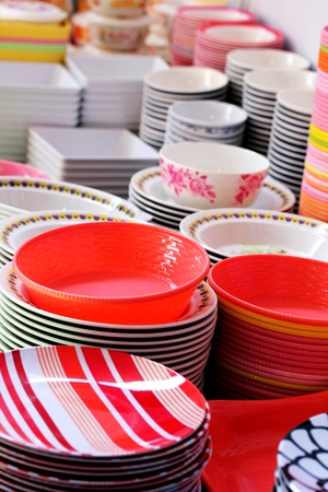 Colorful melamine, ceramic, china clay and plastic bowls arranged for sale in a marketの写真素材
