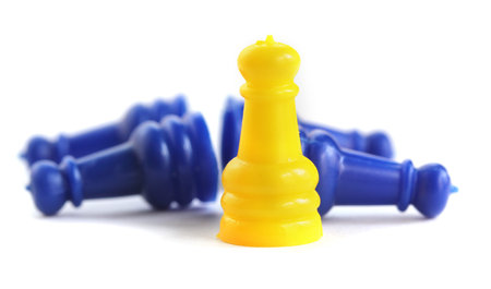 Concept of winning and success in business - yellow plastic toy standing as a champion beating the...