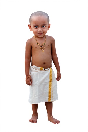 Cute and handsome happy indian boy with naughty smile waering traditional south indian(kerala) dress callled mundu and decorated with gold ornamentsの写真素材