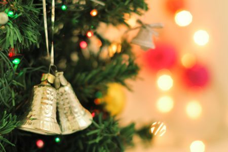 Bells decoration hanging on the Christmas tree with lightsの写真素材