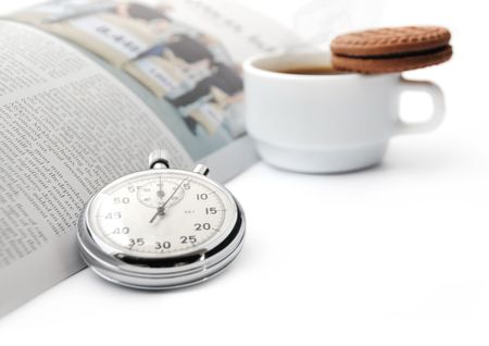 Stopwatch on the background of a newspaper and a cup of coffee with biscuit  short break of a businessmanの写真素材