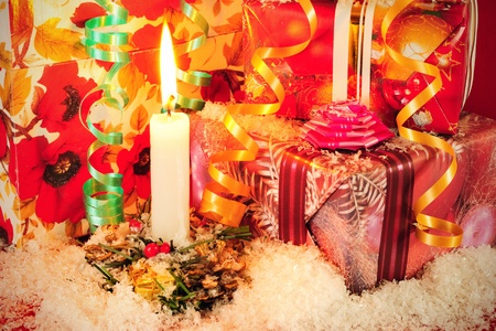 Christmas background with decorative gift boxes, candle, artificial snow and stripsの写真素材