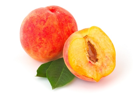 Half-cut and whole juicy peaches with leaves on white backgroundの写真素材