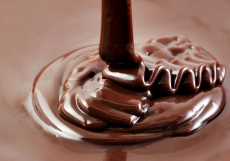 Ribbons of pouring hot chocolate, sweet cooking backgroundの写真素材
