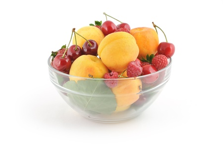 Glass bowl full of fresh delicious berries on white backgroundの写真素材