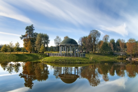 Idyllic autumn landscape  Lake with island and arbor with colorful trees and sky reflection の写真素材