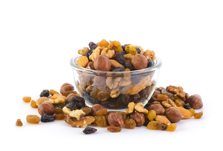 A variety of nuts and raisins in a glass bowl on white background の写真素材