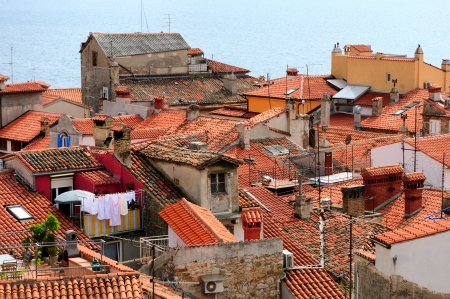 Beautiful red roofs of Mediterranean town, Piran in Slovenia, with sea on the background の写真素材