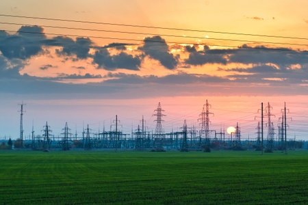Electric power station pylons and wires at sunset