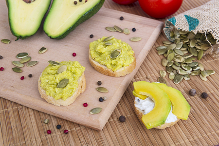 Cooking vegan breakfast with avocado toasts, seeds and vegetablesの写真素材