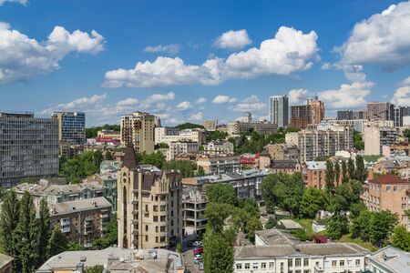 Hot summer cityscape in Kyiv, Ukraine. Old and modern buildings, clear blue sky with cloudsの写真素材