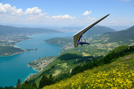 2014-06-25 Annecy, France. Hang glider pilot do aerobatic maneuvers over lake Annecy. Popular place for doing extreme sports.のeditorial素材
