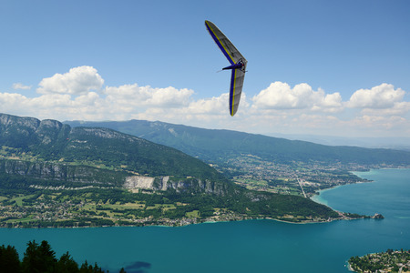 2014-06-25 Annecy; France. Hang glider pilot do extreme aerobatic maneuvers over lake Annecy. Popular place for airborne sports.のeditorial素材