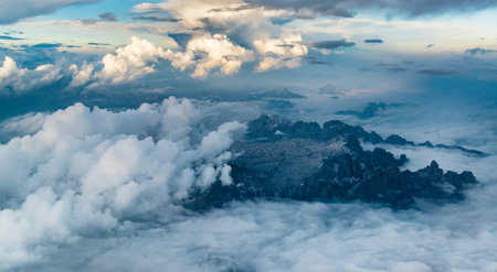 Amazing aerial panorama. Sharp rocks, mountain chains and clouds from high altitude.