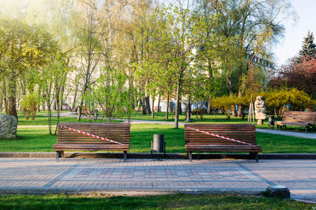 Kyiv, Ukraine, empty city park during quarantine 2020. Visiting parks is prohibited, benches are...